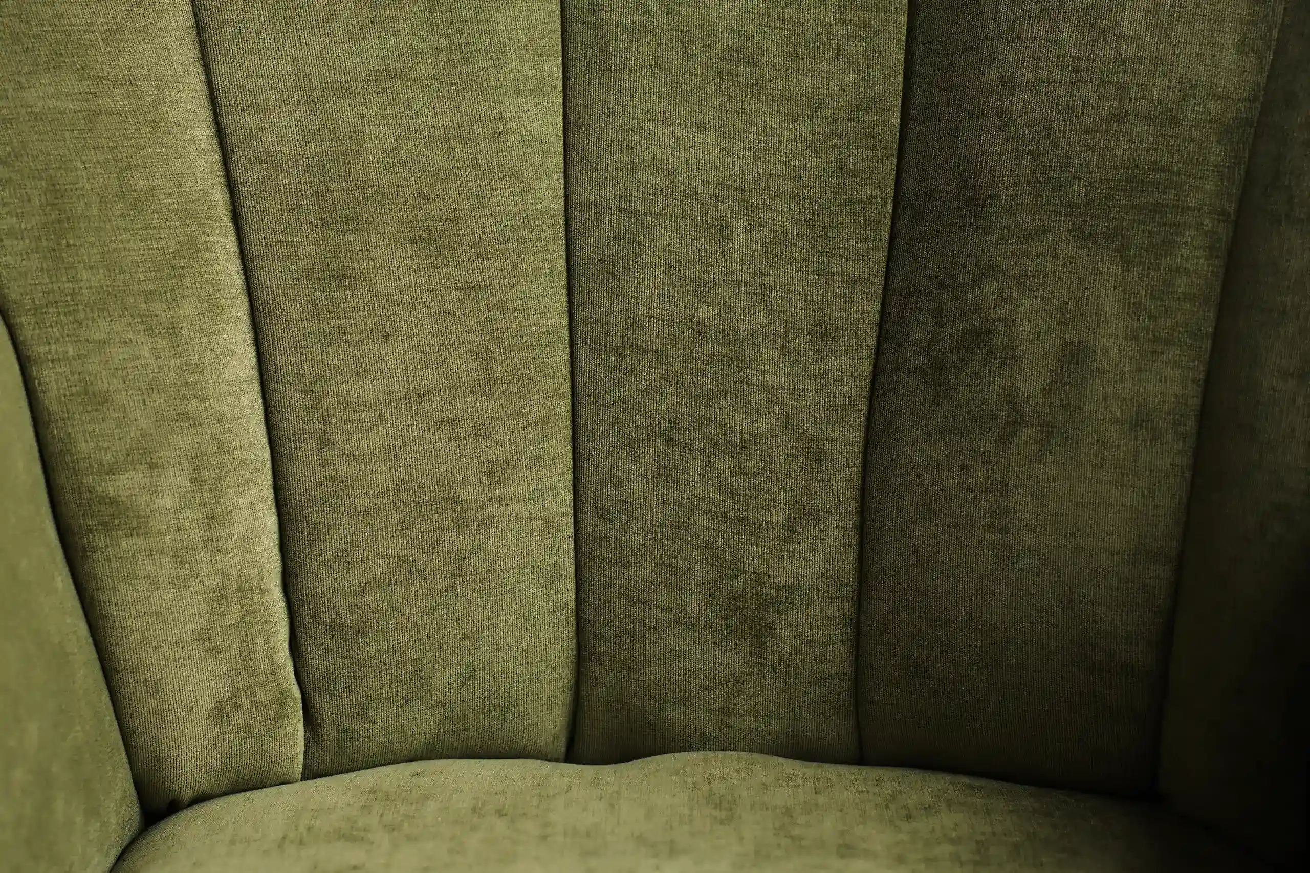 Velours vert olive d’un fauteuil à côtes en gros plan, photo d’ambiance de l’identité de Plume notaires