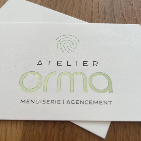 Gros plan sur le relief du marquage à chaud vert pâle d’une carte de visite Atelier Orma imprimée par La petite Frappe