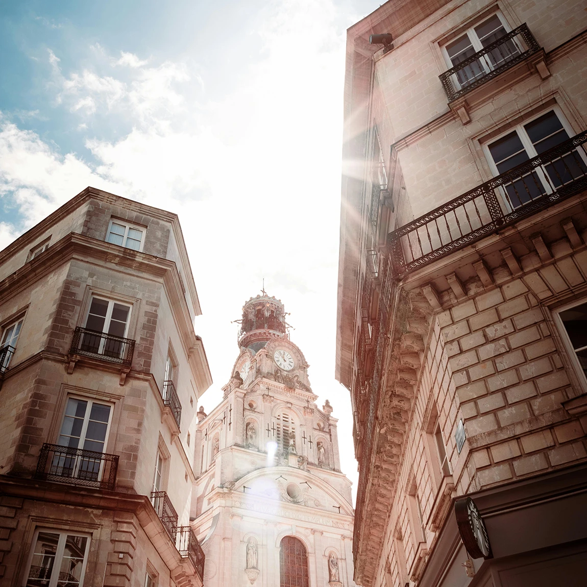 Façades en tuffeau et clocher de l'église Sainte-Croix à Nantes, image d'ambiance de l'univers d'Augus Avocats