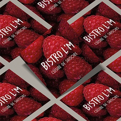 Cartes de visite Bistro L’M imprimées sur une photo de framboises, logo blanc « Cuisine de saisons »