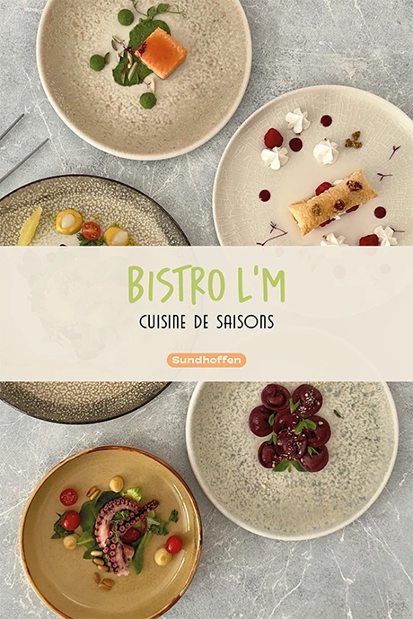 Logo Bistro L’M vert anis sur un bandeau crème entre des assiettes gastronomiques vues du dessus