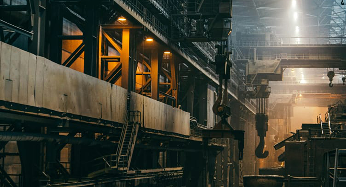 Intérieur d’une aciérie avec passerelles métalliques et crochets de pont roulant, photo d’ambiance industrielle de Catalyst Formation