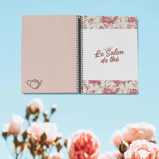 Menu du salon de thé Chez Marion à spirale : couverture « Le Salon de thé » en toile de Jouy rose et théière dessinée