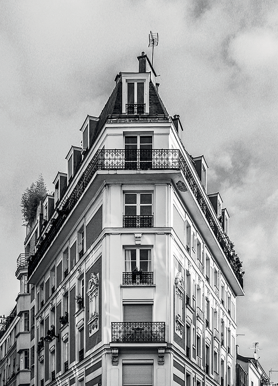 Immeuble d’angle de style haussmannien en noir et blanc, photo d’ambiance de l’identité parisienne d’Etrainers