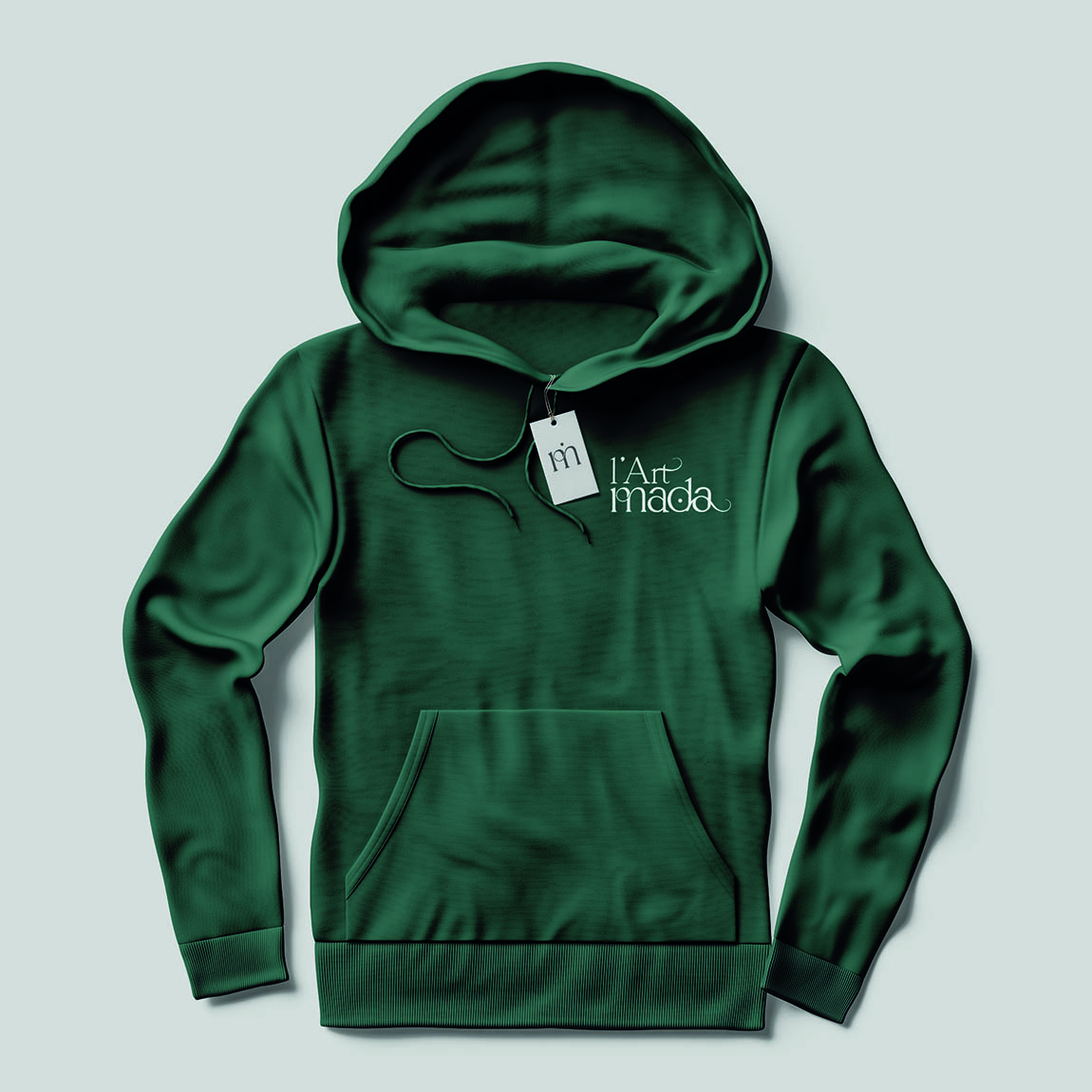 Sweat à capuche vert sapin marqué du logo blanc L’Art Mada, avec une étiquette au monogramme lm